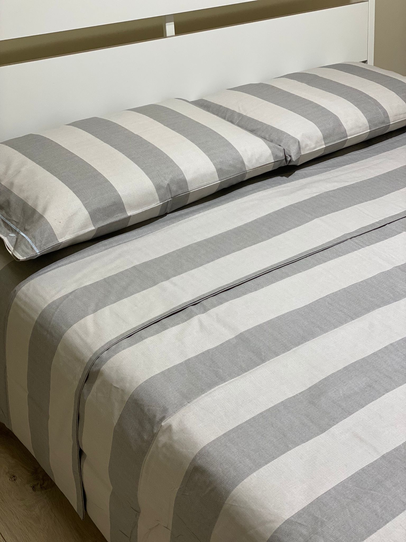 Tappeto bianco e letto king size con lenzuola grigio nella spaziosa e  luminosa camera da letto con poster scuro Foto stock - Alamy